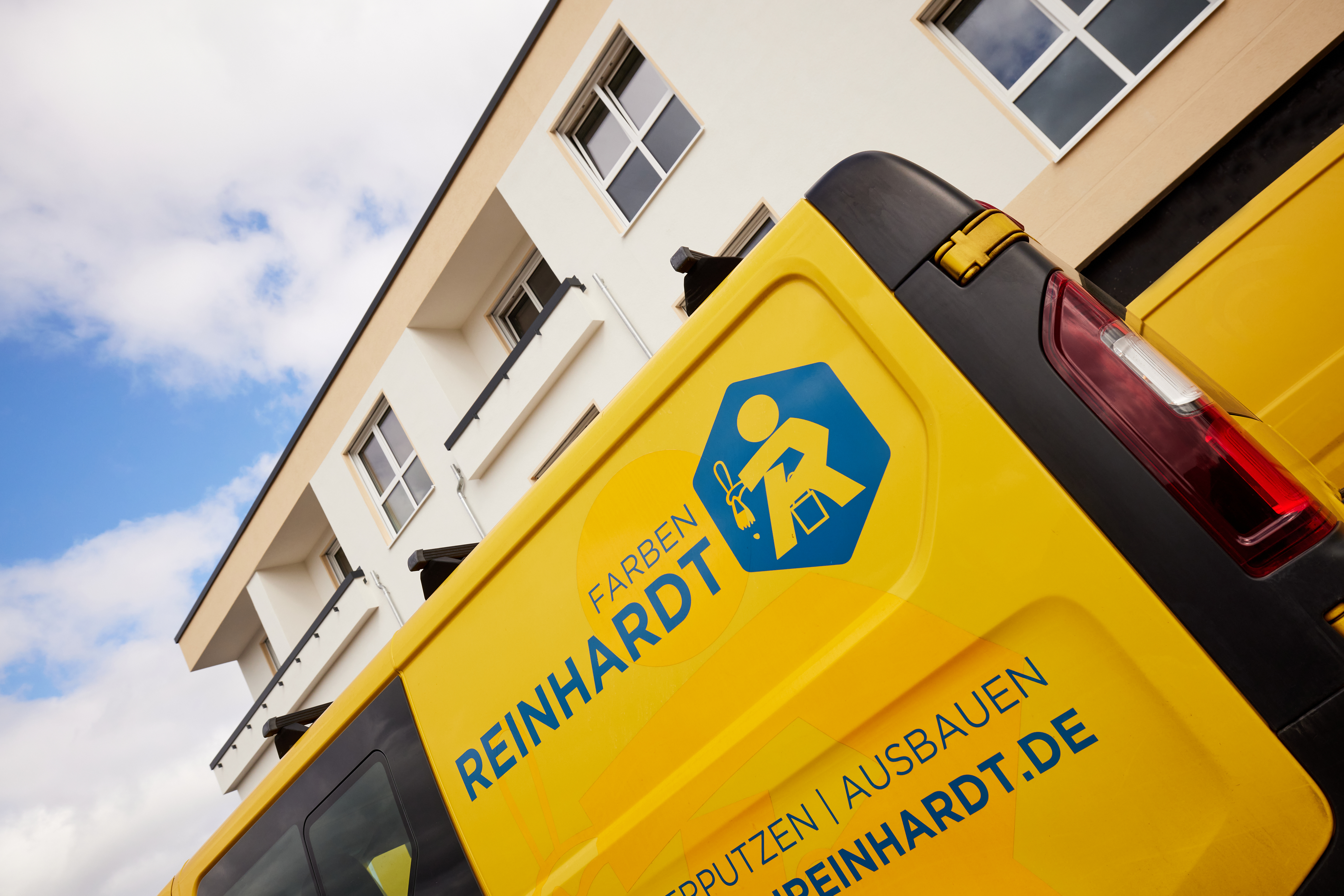 Angeschnittenes Bild eines Firmenfahrzeug auf der Baustelle vor einem Gebäude