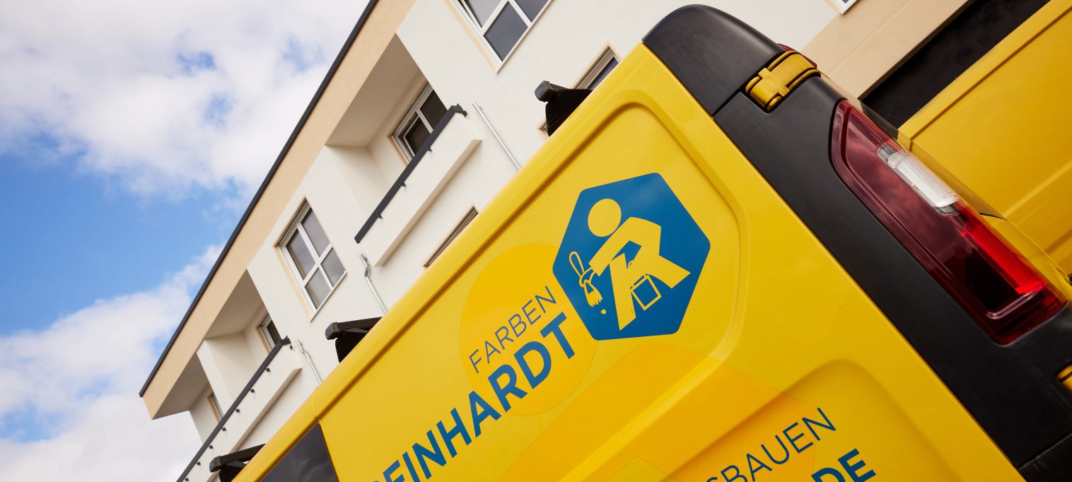 Angeschnittenes Bild eines Firmenfahrzeug auf der Baustelle vor einem Gebäude