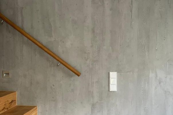 Seitliche Ansicht eines Treppenaufgangs mit veredelter Oberfläche der Wand in Betonoptik